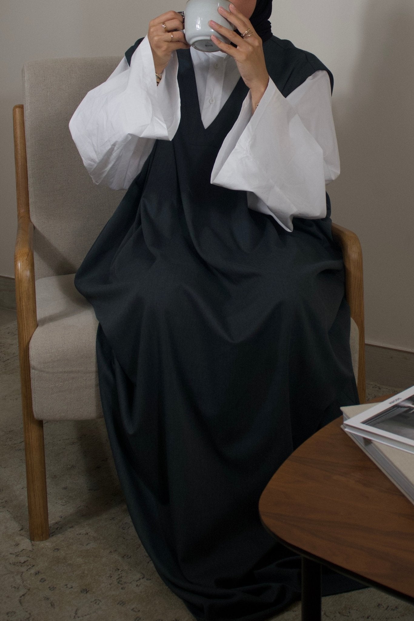 abaya amara verte mannequin boit une tasse de thé et met les manches longues et le col v en évidence